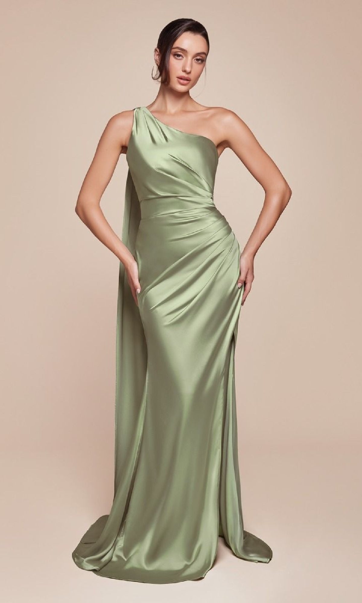 A woman poses against a neutral background in the Ladivine 7454 One-Shoulder Sash Long Prom Dress—a light green, floor-length satin gown with a draped, fitted design.